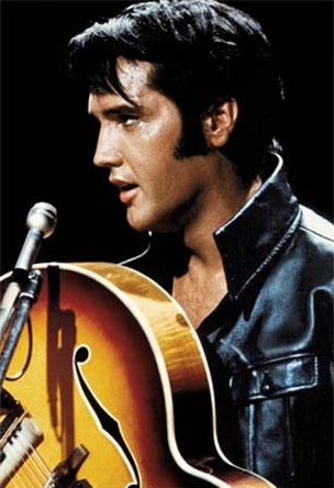 Close  sideview shot of Elvis Presley wearing black leather jacket onstage with guitar, 1968 Comeback Special. Color photograph 24" x 36" poster