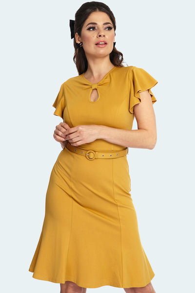 A model wearing a mustard colored knee length dress with a fitted bodice, twisted keyhole detail neckline, short flutter style sleeves, and a matching belt