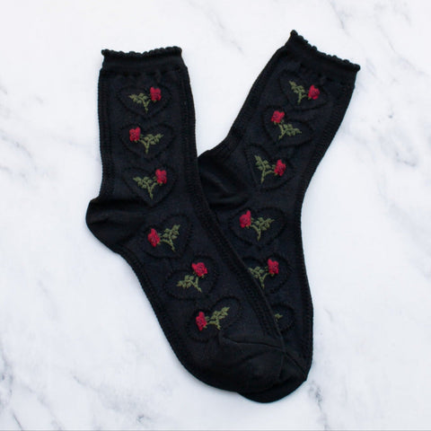 Cozy cotton knit socks in black with an all-over knit-in pattern of a rose with its stem inside of a scalloped heart. Ruffled cuff in matching black