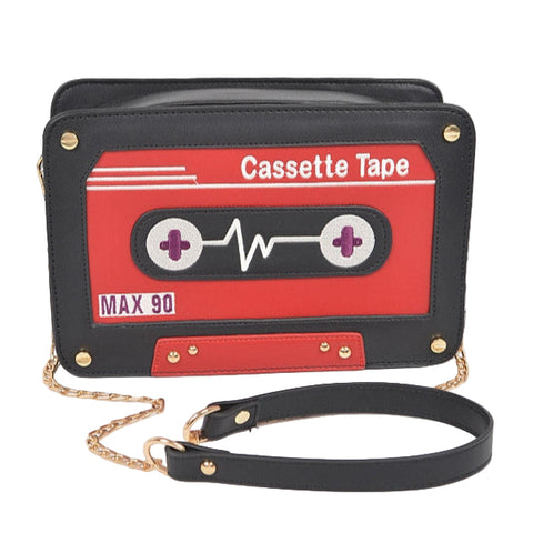 Cassette tape-shaped handbag with red, purple, and black design and gold hardware on a white background. Shown from front