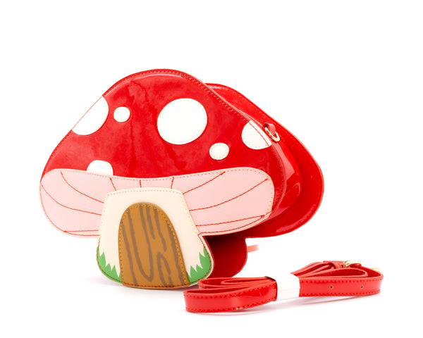 red and white spotted toadstool mushroom house with wooden door shaped purse. Shown with matching strap