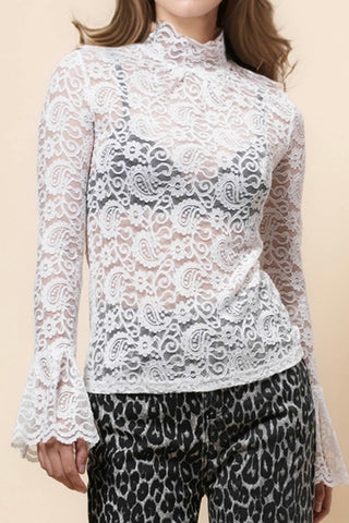 model wearing white floral and paisley patterned lace long sleeve top with a high ruffled neck and wide ruffled cuffs. Shown from front