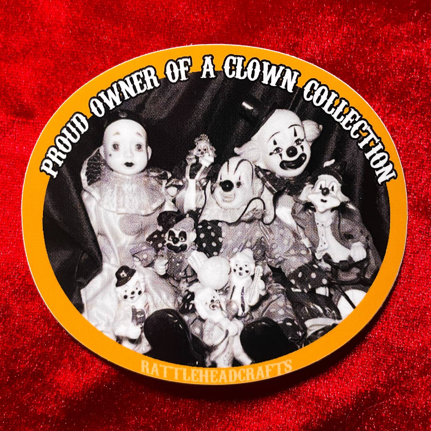 round glossy die-cut vinyl sticker with caption "PROUD OWNER OF A CLOWN COLLECTION" and black & white photo of a collection of clown figurines with orange border