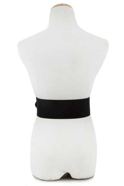 Zebra print belt with a self buckle and black elastic back on a dress form shown from the back