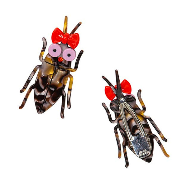 Acrylic brown swirled cockroach-shaped hair clip with large light pink eyes, red bow attached to antennas, and red rhinestone nose. Shown from front and back with silver alligator styled hair clip on back
