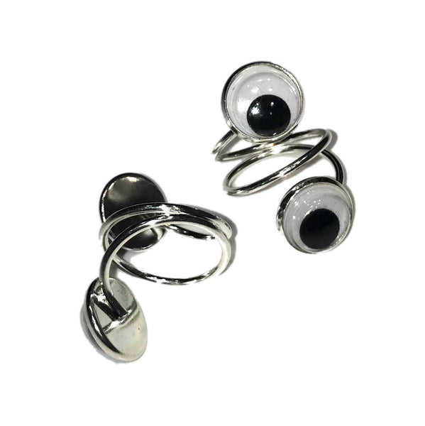 Pair of ilver metal spiral-shaped rings with face of ring adorned with two plastic black and white googly eyes. Shown flat from top and bottom