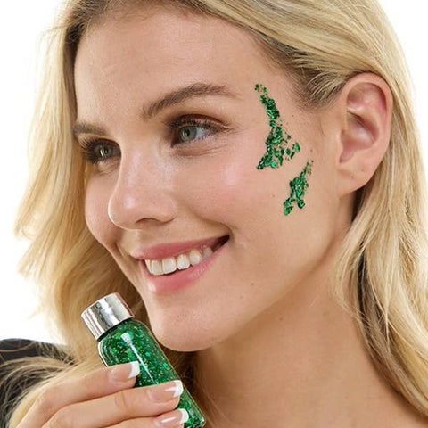 Woman applying green decorative glitter makeup with a brush on a white background
