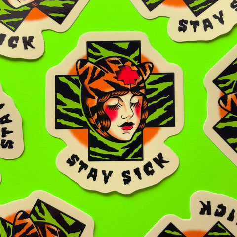 Sticker with stylized face of Poison Ivy wearing a tiger hat in front of green and black tiger print and 'Stay Sick' text on a green background.