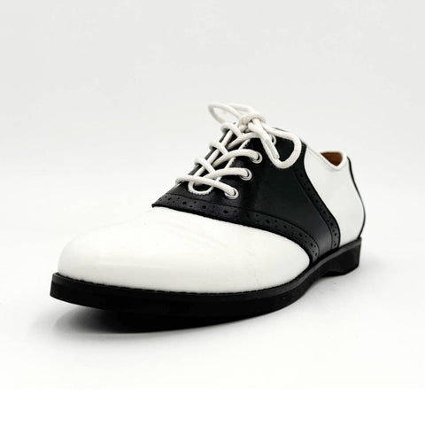 Black and white brogue style saddle shoes with black soles and white laces. Shown from a three quarter angle