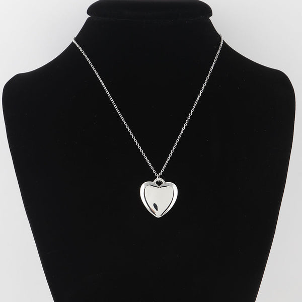 large silver metal heart pendant on an 18" silver metal link style chain. Shown on dress form