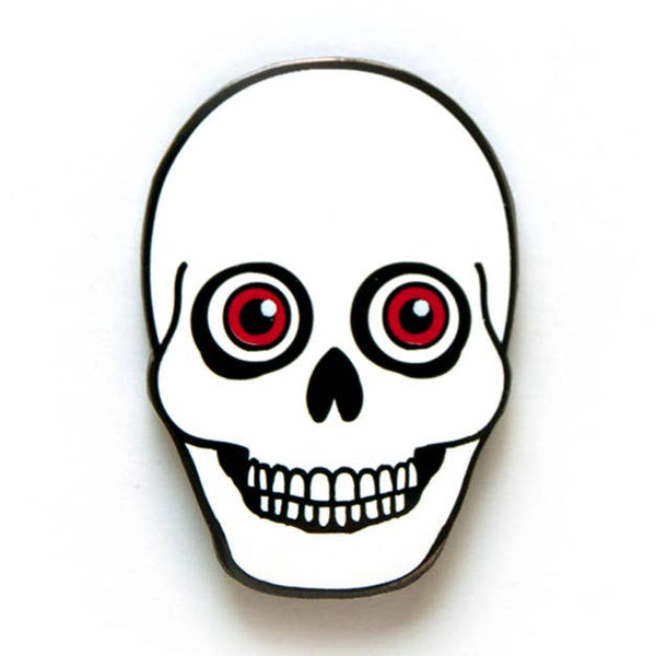 Black metal enamel pin of a white smiling skull with large red eyes 