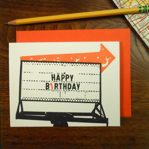 Rectangular letter press birthday card with an illustration of a run-down vintage sign with lit arrow and caption “Happy b1rthday”