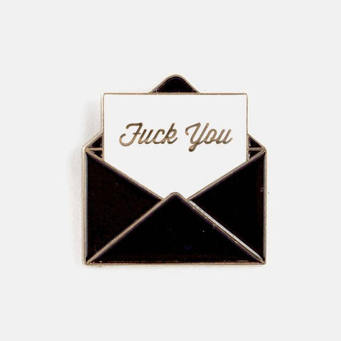 Gold enamel pin of a black envelope opened to reveal a piece of paper with the message “Fuck you” written in cursive. Shown from the front 