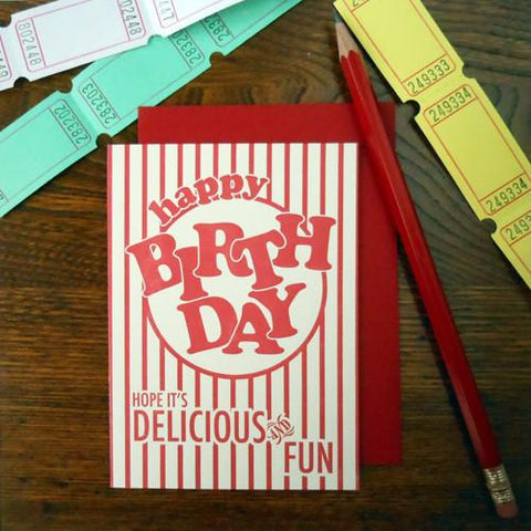 Rectangular letterpress greeting card designed to resemble old fashioned popcorn packaging with message “happy BIRTHDAY” “Hope it’s delicious and fun” in bright red 