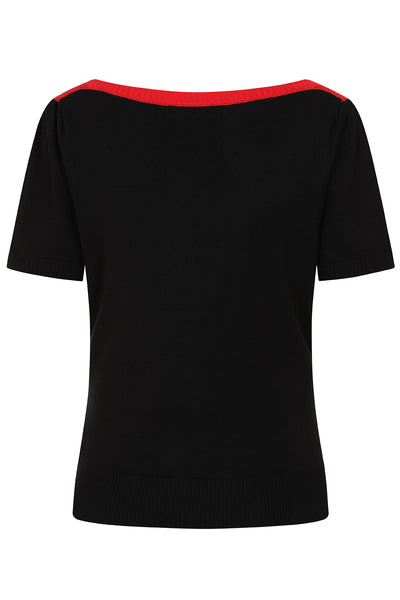 Short sleeve knit sweater with red slash neck and creamy white chest panel color blocked with black meeting at a row of black outlined white diamond shapes with tiny red hearts in the middle. Shown from back with solid black body