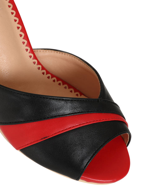 a pair of faux leather peep-toe heels with black and red striped toe strap, black ankle strap with gold metal buckle, and red insole. shown in close up of toe strap detail