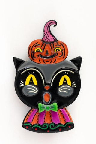 layered resin acrylic brooch in the shape of a black cat with surprised look on its face wearing a green bowtie & orange and pink striped outfit with a small jack-o'-lantern on its head that has a pink stem. Shown flat