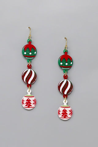Acrylic dangle earrings in the shape of three holiday tree ornaments each connected to each other with an o ring. Glittery acrylic with a Santa hat pattern, candy cane stripes, and a red and white tree pattern