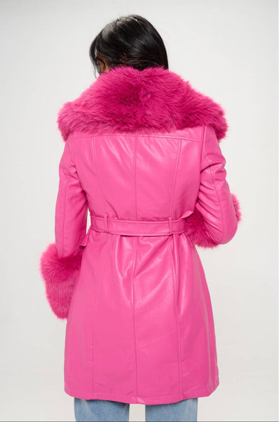 Model wearing hot pink faux fur trench coat with oversized hot pink faux fur shawl collar and wide cuffs. Shown buttoned up from the back