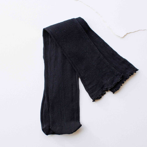 black cotton knit knee high socks with rolled top band in a classic black geometric openwork design. Shown lying flat