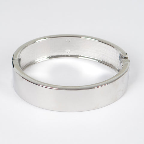 shiny silver metal hinged bangle. Shown on its side