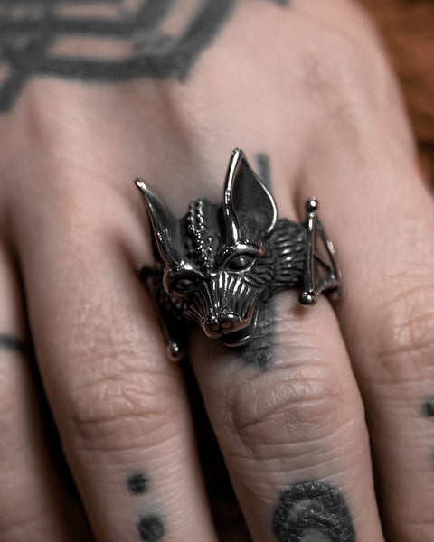 Model wearing a stainless steel ring in the shape of a highly detailed bat’s head and wings. Shown from a right angle
