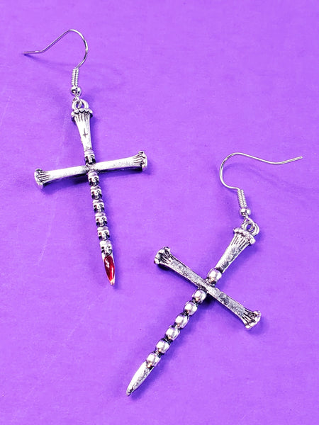 pair of silver metal dagger earrings with a blade made of tiny skulls & a bloody red jewel at each tip