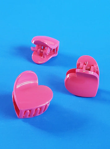 glossy plastic heart shaped claw-style hair clip in a bubblegum pink color, showing three different views