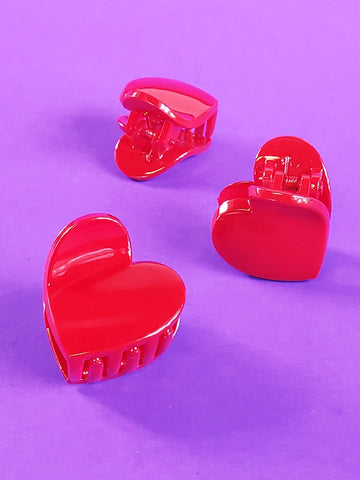 glossy plastic heart shaped claw-style hair clip in a beautiful rich red color, showing three different views