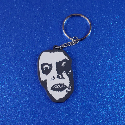 Soft-touch finish black and white rubber keychain of Captain Howdy from The Exorcist 