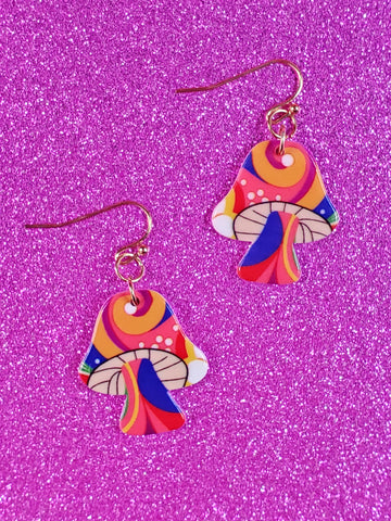 70s inspired enameled acrylic mushroom dangle earrings with a cap and stem decorated with swirls of orange, yellow, blue, red, and green