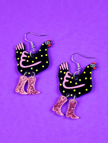 Black chicken with yellow spots and pink highlights wearing pink glittery cowboy boots acrylic dangle earrings