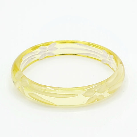 translucent pale lemon yellow resin bangle with reverse carved floral motif interior