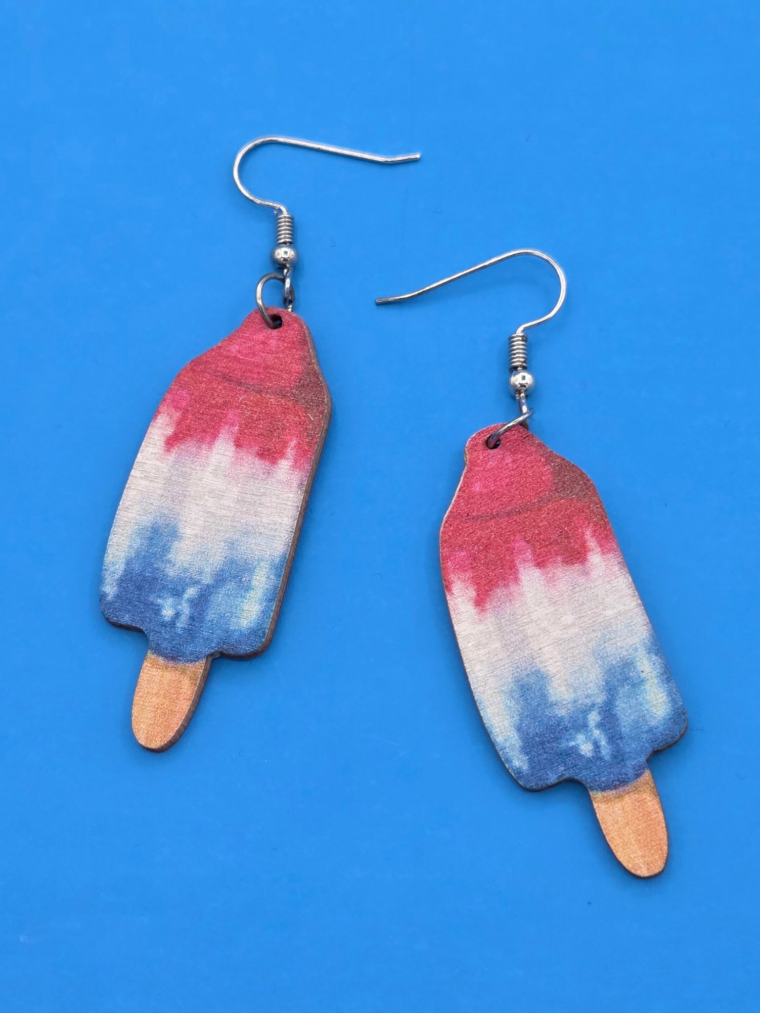 wooden dangle earrings laser cut and printed with images of red white and blue popsickles