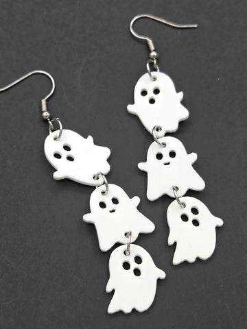pair of dangle earrings, each comprised of three graduated size shiny white laser-cut acrylic cartoon ghosts linked together in a line