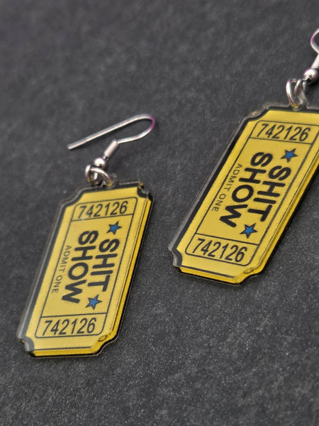 Yellow ticket shaped acrylic earrings with SHIT SHOW ADMIT ONE lettering in black