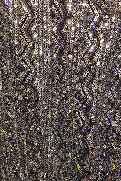 Close-up of a sequined fabric with a zigzag pattern.