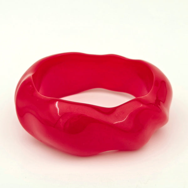 shiny slightly irregular wavy-shaped resin bangle in a shade of candy apple red