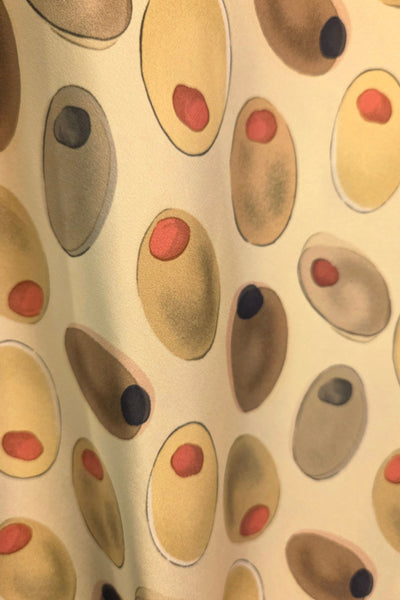 Pattern of stylized olives on a light green background fabric swatch close up
