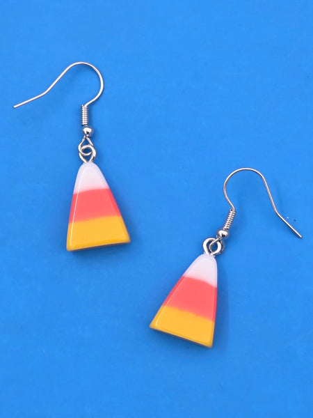 Candy corn-shaped earrings on a blue background