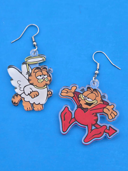 Pair of Garfield the cat dressed as a devil and angel acrylic dangle earrings on a blue background