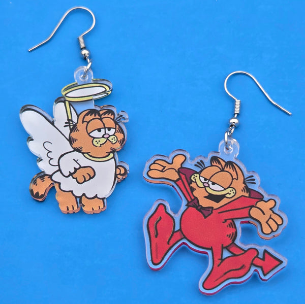 Pair of Garfield the cat dressed as a devil and angel acrylic dangle earrings on a blue background