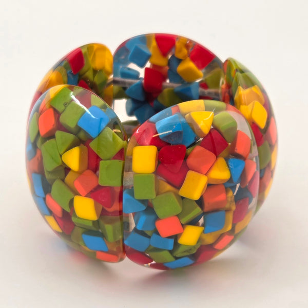 Multicolored shapes in resin bracelet on a white background