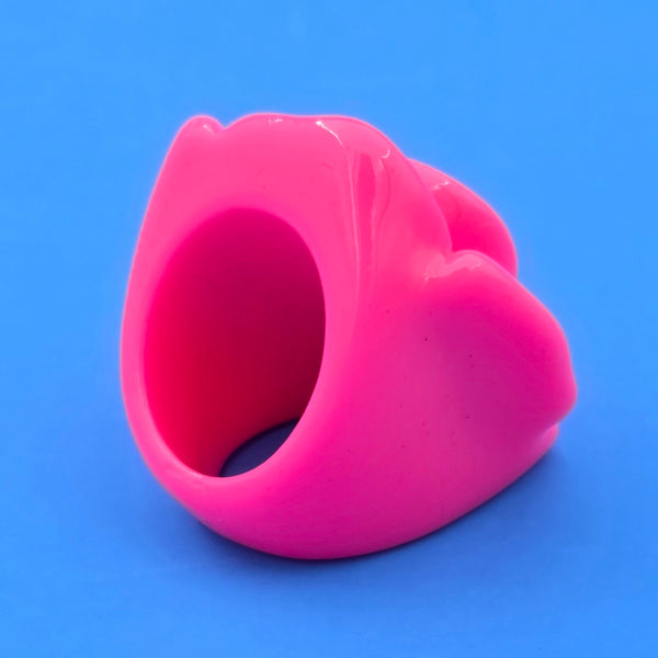 neon pink resin rose ring on blue background, shown 3/4 back view