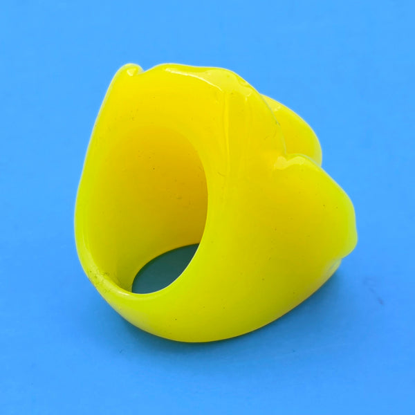 neon yellow resin rose ring on blue background, shown 3/4 back view
