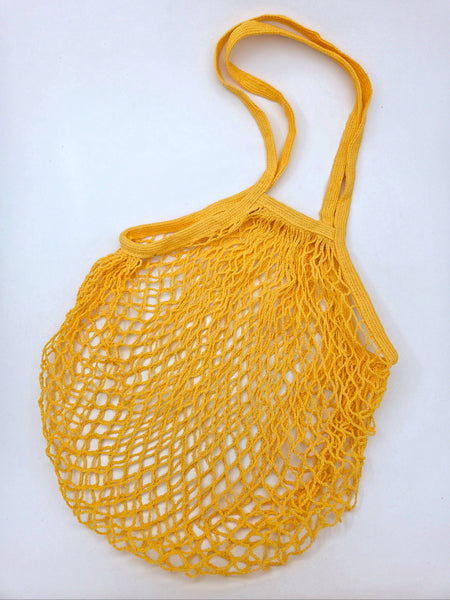 Yellow cotton mesh shopping bag on a white background