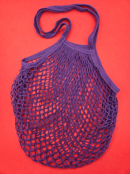 Purple cotton mesh shopping bag on a red background