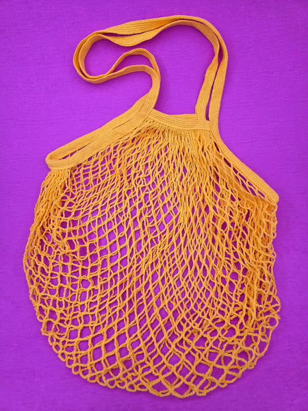 yellow cotton mesh shopping tote shown on a purple background