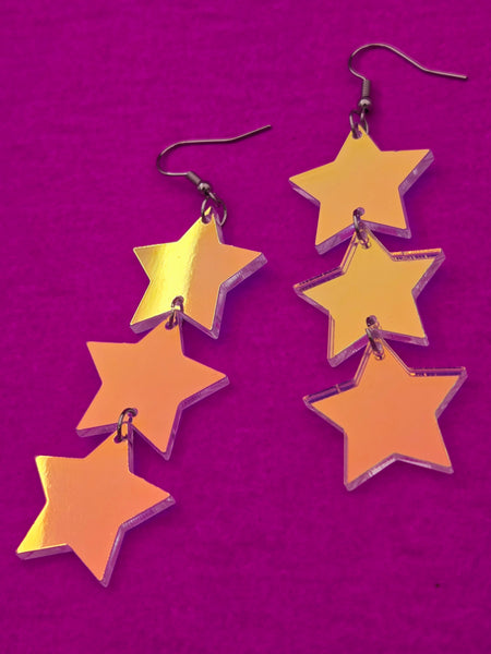 flash finish clear acrylic star-shaped earrings on a purple background