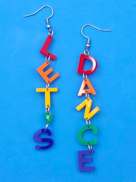 'LET'S DANCE' earrings, one earring spelling out each word in rainbow laser cut acrylic letters, on a white background
